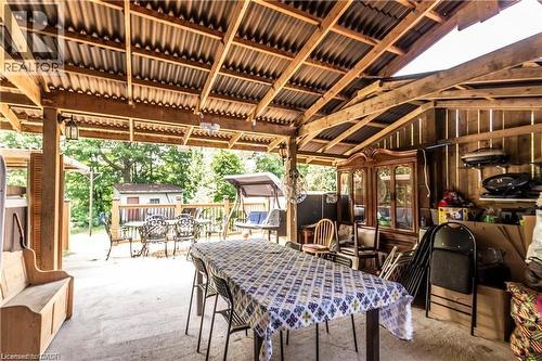 Covered outdoor living space featuring exposed wood beam construction and a corrugated metal roof - 404 Queenston Road, Hamilton, ON 