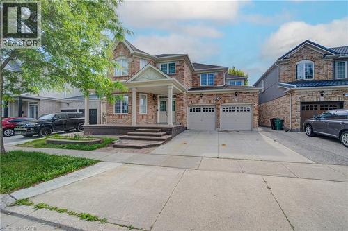 Brick facade residence featuring a covered porch with white columns, a double garage, and a concrete driveway - 180 Arthur Fach Drive, Cambridge, ON 