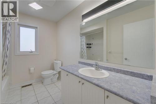 Full bathroom featuring a white vanity with a blue-grey countertop, an integrated sink, and a large wall-mounted mirror - 180 Arthur Fach Drive, Cambridge, ON 