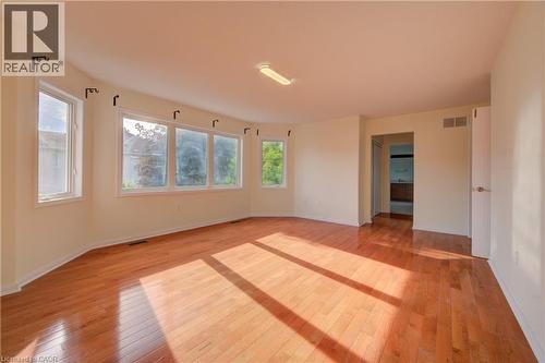 Spacious interior room featuring hardwood flooring, a curved wall with multiple windows, and a recessed ceiling light fixture - 180 Arthur Fach Drive, Cambridge, ON 