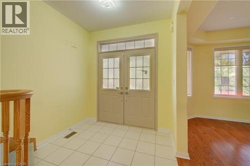 Entry foyer featuring double doors with decorative glass panels and an overhead transom window - 180 Arthur Fach Drive, Cambridge, ON 