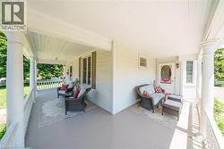 Expansive covered porch featuring a painted floor, architectural support columns, and a decorative railing - 