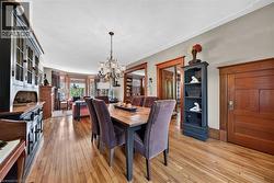 Spacious room featuring wood-finish flooring, a chandelier, and a built-in hutch - 