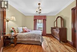 Hardwood flooring, crown molding, and wainscoting enhance this room - 