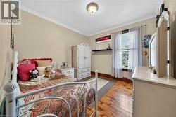 Hardwood flooring throughout featuring light-toned walls and crisp white crown molding - 