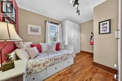 Interior room featuring wood-finish flooring, a single window, and neutral wall paint - 