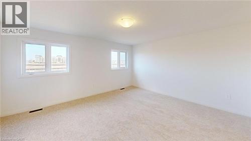 Spacious room featuring neutral carpeting, white painted walls, and two multi-pane windows - 200 Cittadella Boulevard, Hamilton, ON 