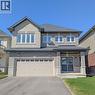 Brick and stone facade residence featuring a double-door entry with sidelights, an attached two-car garage, and multiple large windows - 200 Cittadella Boulevard, Hamilton, ON 