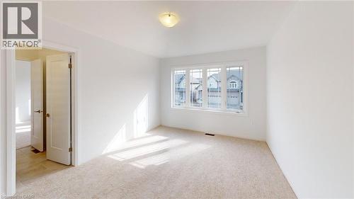 Bright room featuring a multi-pane window, neutral-toned carpeting, white walls, and a flush mount ceiling light - 200 Cittadella Boulevard, Hamilton, ON 