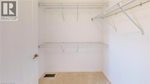 Walk-in closet featuring wire shelving, white walls, and light-colored carpet - 200 Cittadella Boulevard, Hamilton, ON 