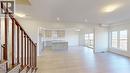 Wood-finish staircase with visible grain, light wood-finish flooring, recessed lighting, large windows, and a kitchen featuring light cabinetry and a central island - 200 Cittadella Boulevard, Hamilton, ON 