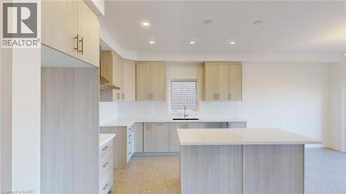Kitchen featuring light wood-finish cabinetry, white countertops, a central island, recessed lighting, and a stainless steel sink with a black faucet - 200 Cittadella Boulevard, Hamilton, ON 