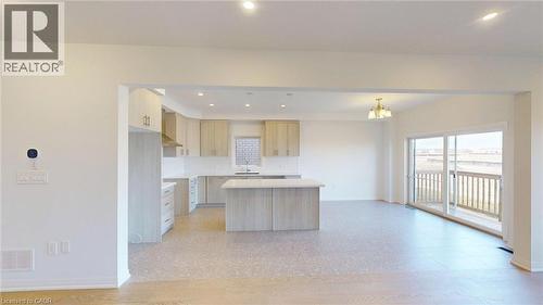 Open-concept living space featuring a contemporary kitchen with light wood-finish cabinetry, a central island, and recessed lighting - 200 Cittadella Boulevard, Hamilton, ON 