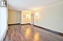 Spacious room featuring wood-finish flooring, two doors, and wall-mounted sconce lighting - 1476 Barton Street E Unit# 2, Hamilton, ON 