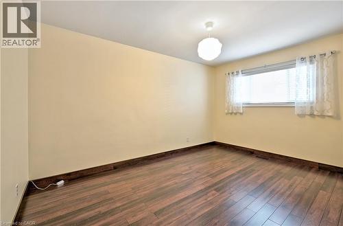 Room featuring wood-finish flooring, light-toned walls, and a ceiling-mounted light fixture - 1476 Barton Street E Unit# 2, Hamilton, ON 