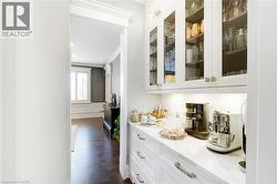 Integrated white cabinetry featuring glass panel doors and under-cabinet lighting - 