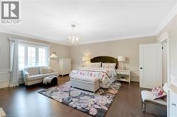 Spacious room featuring dark wood-finish flooring, white paneling, and crown molding - 