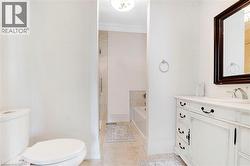 Bathroom featuring a white vanity with a light-toned countertop, an undermount sink, and a dark framed mirror - 