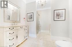 Bathroom featuring a vanity with an integrated sink, a framed mirror, and a crystal chandelier - 