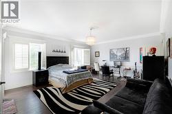 Spacious room featuring dark wood-finish flooring, multiple windows with white plantation shutters, and extensive white crown molding - 