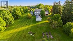 Expansive green lawn with mature trees and a detached outbuilding - 
