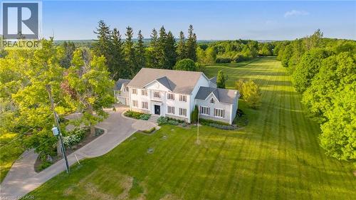 Expansive property featuring a large residence with light-colored siding and a dark roof - 6195 Milburough Line, Burlington, ON - Outdoor With View