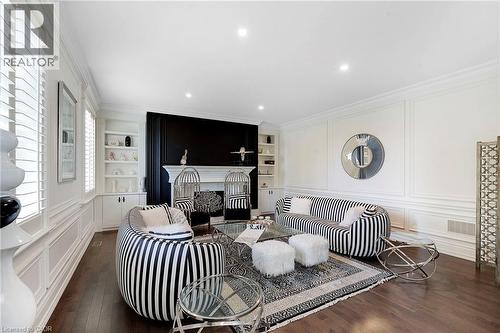 Spacious room featuring rich wood-finish flooring and extensive white wall paneling - 6195 Milburough Line, Burlington, ON - Indoor Photo Showing Living Room