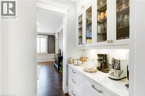 Integrated white cabinetry featuring glass panel doors and under-cabinet lighting - 6195 Milburough Line, Burlington, ON - Indoor