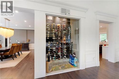 Built-in glass-enclosed wine cellar featuring extensive bottle storage - 6195 Milburough Line, Burlington, ON - Indoor