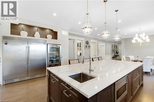 Spacious kitchen island featuring a waterfall-edge countertop, undermount sink, and integrated microwave drawer - 6195 Milburough Line, Burlington, ON - Indoor Photo Showing Kitchen With Upgraded Kitchen
