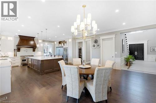 Spacious open-concept interior featuring wood-finish flooring, recessed lighting, and a contemporary chandelier - 6195 Milburough Line, Burlington, ON - Indoor Photo Showing Dining Room