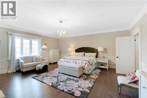 Spacious room featuring dark wood-finish flooring, white paneling, and crown molding - 6195 Milburough Line, Burlington, ON - Indoor Photo Showing Bedroom