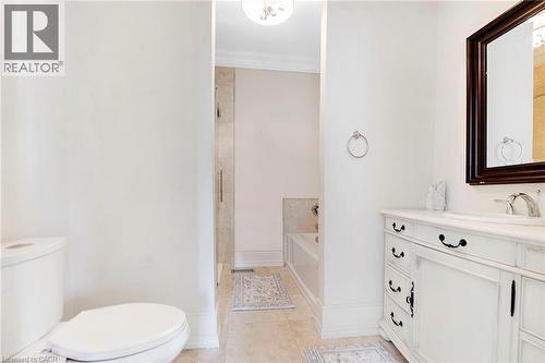 Bathroom featuring a white vanity with a light-toned countertop, an undermount sink, and a dark framed mirror - 6195 Milburough Line, Burlington, ON - Indoor Photo Showing Bathroom