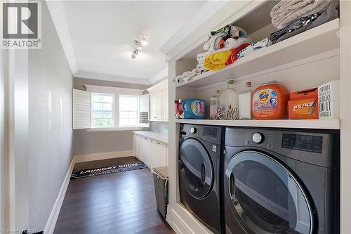Laundry area featuring wood-finish flooring, white shaker cabinetry, and a light-toned countertop - 6195 Milburough Line, Burlington, ON - Indoor Photo Showing Laundry Room