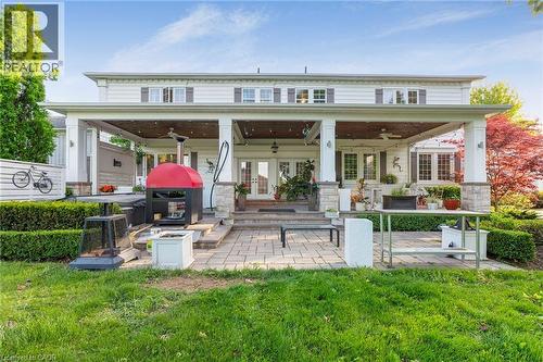 Expansive outdoor living area featuring a covered patio, extensive paver patio, a built-in outdoor cooking station, and manicured landscaping - 6195 Milburough Line, Burlington, ON - Outdoor