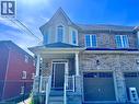 Stone and siding facade featuring a prominent gabled entry, bay window with arched transom, covered front porch, and an integrated single-car garage with arched window accents - 154 Rosemount Drive, Kitchener, ON 