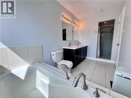 Modern bathroom featuring a dual vanity with a dark wood-finish cabinet, white countertop, and rectangular sinks - 154 Rosemount Drive, Kitchener, ON 