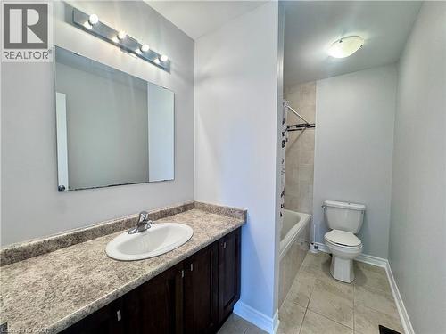 Bathroom featuring a vanity with an integrated sink, dark wood-finish cabinetry, and a speckled countertop - 154 Rosemount Drive, Kitchener, ON 