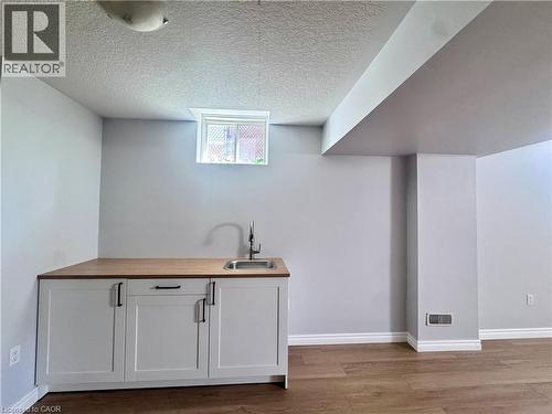 Built-in cabinetry with wood-finish countertop, stainless steel sink, and gooseneck faucet - 154 Rosemount Drive, Kitchener, ON 