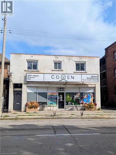 Two-story commercial building featuring a white brick facade - 949 E Main Street E, Hamilton, ON 