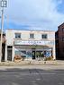 Two-story commercial building featuring a white brick facade - 949 E Main Street E, Hamilton, ON 