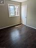 Room featuring dark wood-finish flooring, light tan walls, and white baseboards - 949 E Main Street E, Hamilton, ON 