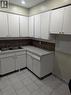 Kitchen featuring white cabinetry, tile flooring, a double basin stainless steel sink, and a tiled backsplash - 949 E Main Street E, Hamilton, ON 