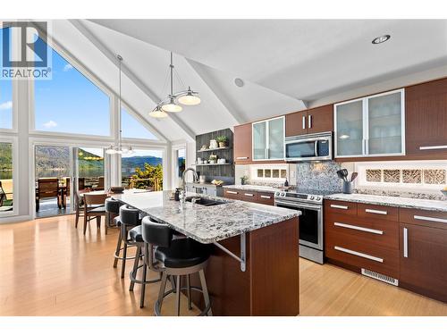 Large open plan kitchen with granite counters bar seating at the island and dinning room table  all with a view - 6421 Eagle Bay Road Unit# 13, Eagle Bay, BC 