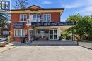 Two-story brick building featuring a ground-level commercial storefront with an awning, large display windows, and a double-door entry - 744 Queen Street S, Kitchener, ON 