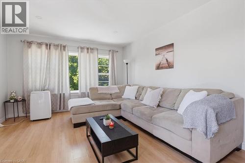 Bright living area featuring wood-finish flooring, recessed lighting, and white walls - 744 Queen Street S, Kitchener, ON 