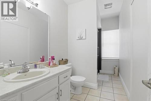 Bathroom featuring a single vanity with an integrated sink, polished chrome faucet, and white cabinetry - 744 Queen Street S, Kitchener, ON 