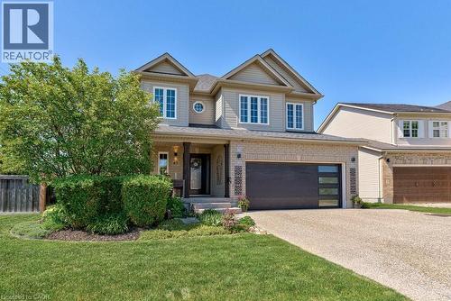 Two-story residence featuring light-colored siding and brick accents, a prominent front porch with dark support columns, a modern dark garage door with horizontal windows, a substantial exposed aggreg - 61 Ditner Avenue, Baden, ON - Outdoor With Facade