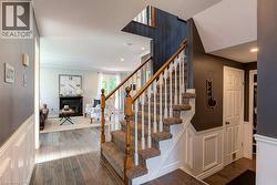 Carpeted staircase with white balusters and wooden handrails - 