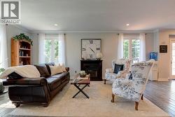 Living area featuring wood-finish flooring, light-toned walls, and recessed lighting - 